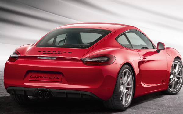 Red Porsche Cayman GTS sports car, rear three-quarter view on a neutral gray backdrop — HD PC desktop wallpaper featuring a Porsche Cayman vehicle.