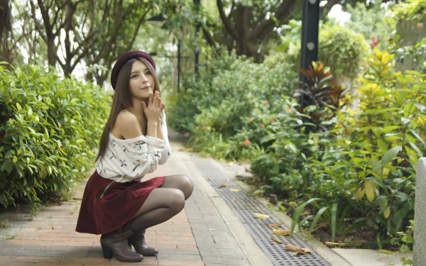 Asian Taiwanese model Julie Chang, wearing a skirt and hat, poses thoughtfully in a lush Hong Kong park. 4K Ultra HD desktop wallpaper by Zhang Qi Jun.
