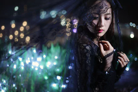 A Taiwanese model, Mikako Zhang Kaijie, adorned in a delicate veil, poses against a backdrop of shimmering lights, creating a captivating nocturnal scene. 