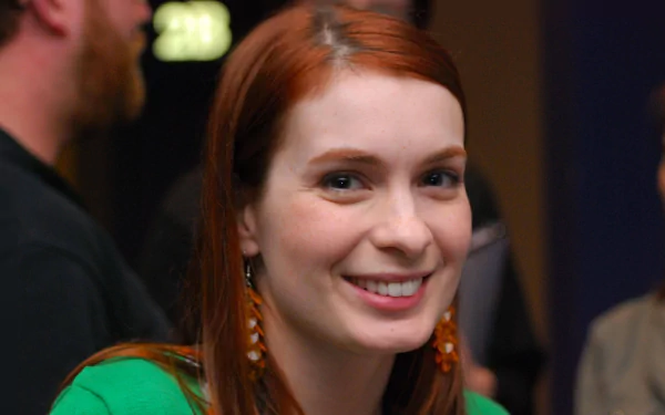 Smiling red‑haired American actress and celebrity in a candid event portrait, presented as a 2K Quad HD PC desktop wallpaper/background.