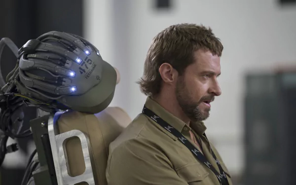 Hugh Jackman as Vincent Moore in a scene from the movie Chappie, featuring the robot character with illuminated components in an HD desktop wallpaper.