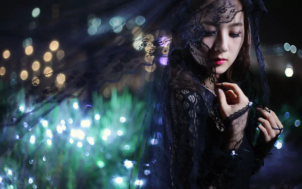 A Taiwanese model, Mikako Zhang Kaijie, adorned in a delicate veil, poses against a backdrop of shimmering lights, creating a captivating nocturnal scene. 