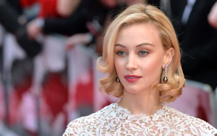 HD desktop wallpaper featuring Canadian actress Sarah Gadon with blonde hair and striking blue eyes, dressed elegantly at a red carpet event.