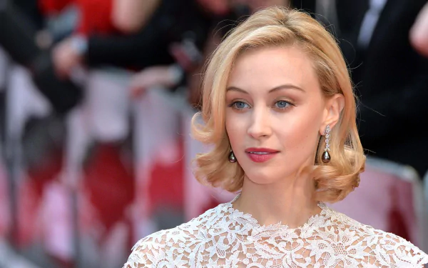 HD desktop wallpaper featuring Canadian actress Sarah Gadon with blonde hair and striking blue eyes, dressed elegantly at a red carpet event.