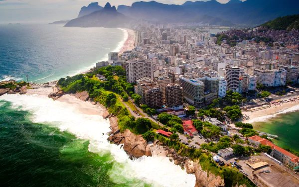 Aerial view of Rio de Janeiro’s coastline featuring sandy beaches, mountainous backdrop, and a sprawling megapolis along Brazil’s man-made urban shoreline.