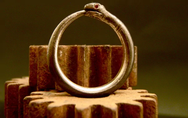HD fantasy desktop wallpaper featuring a detailed ouroboros, a serpent biting its own tail, set against a background of rustic gears.