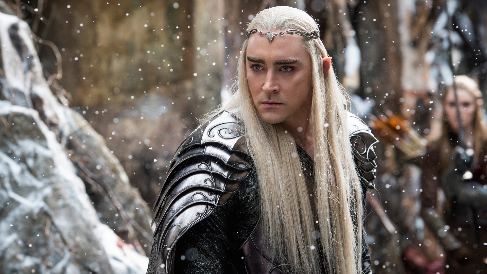 A scene from The Hobbit: The Battle of the Five Armies, featuring a character with long hair and ornate armor amidst falling snow, captured in a high-definition desktop wallpaper.