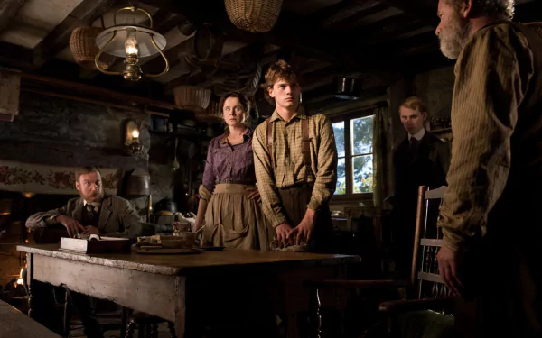 Scene from the movie War Horse showing characters in period clothing gathered in a dimly lit rustic room, presented as an HD PC desktop wallpaper and background.