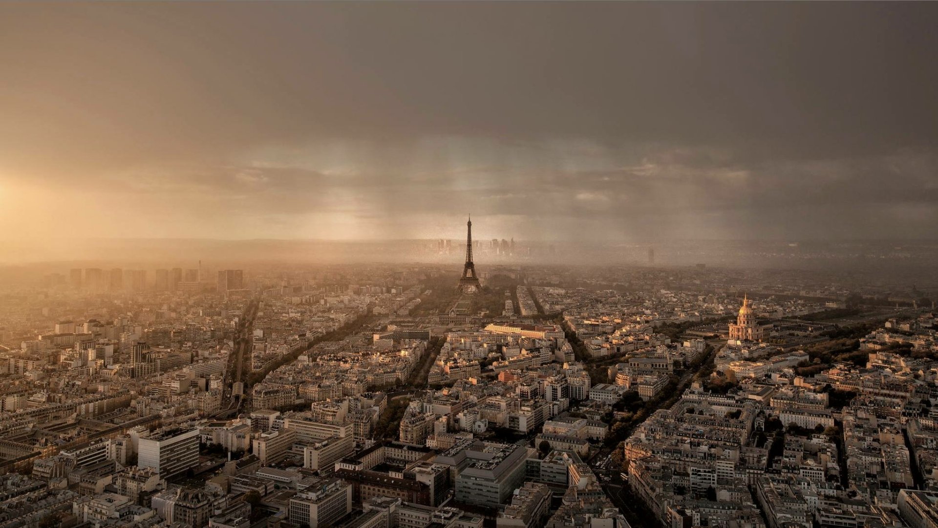 HD PC desktop wallpaper featuring a panoramic view of Paris at sunset, highlighting the Eiffel Tower and cityscape under a dramatic sky.