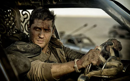 Tom Hardy portrays Max Rockatansky in this intense scene from *Mad Max: Fury Road*, showcasing a rugged character in a post-apocalyptic landscape, captured as a high-definition wallpaper.