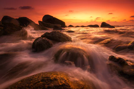 HD PC desktop wallpaper: orange sunset over a Thailand seascape, nature scene of ocean waves rushing around rugged coastal rocks under a glowing sky.