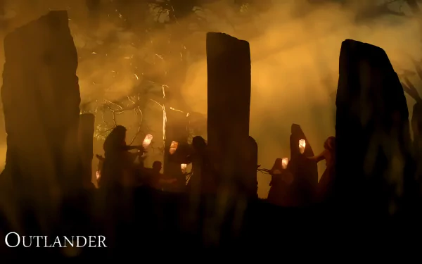 A dramatic scene from the TV show Outlander, featuring shadowy figures with lanterns amidst ancient standing stones, set against a mystical, hazy background.
