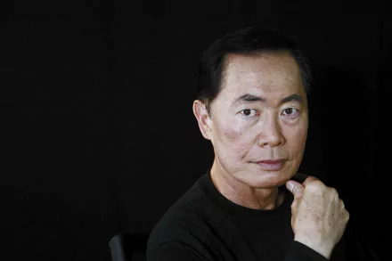 HD desktop wallpaper featuring a portrait of a man with a thoughtful expression, hand on chin, set against a dark backdrop.