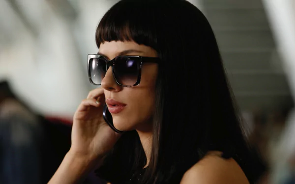 Scarlett Johansson in a still from the movie Lucy, featuring her with sleek black hair and sunglasses, creates a striking 4K Ultra HD desktop wallpaper.