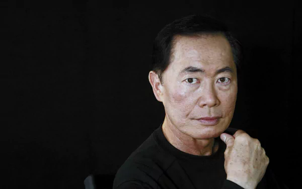HD desktop wallpaper featuring a portrait of a man with a thoughtful expression, hand on chin, set against a dark backdrop.