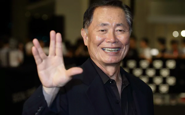 HD wallpaper featuring George Takei smiling and waving, suitable as a desktop background.
