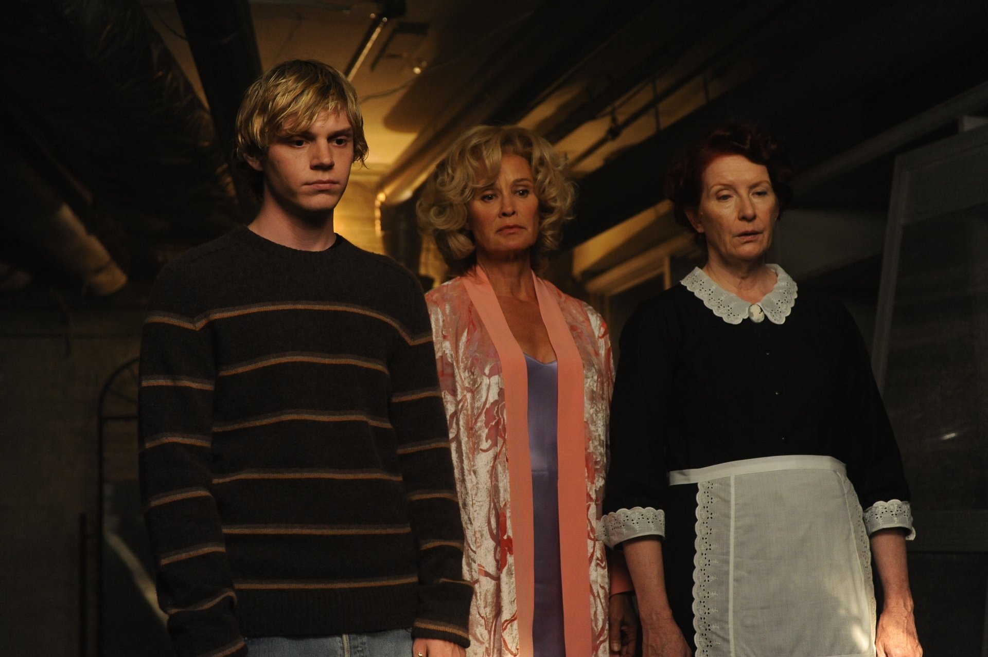 4K Ultra HD wallpaper featuring Evan Peters, Jessica Lange, and Frances Conroy from the TV show American Horror Story in a dimly lit setting.
