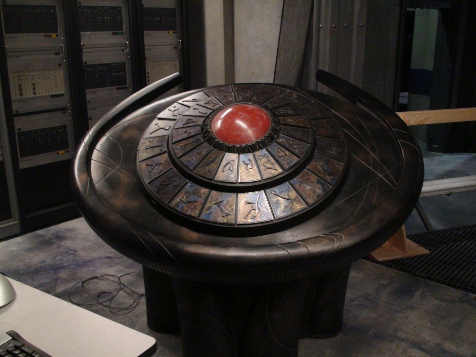DHD dial from the TV show Stargate SG-1 centered in a dim control room — HD PC desktop wallpaper/background.