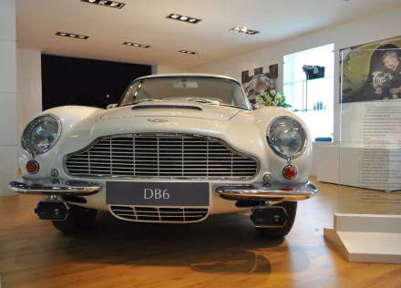 Front view of a white Aston Martin DB6 vehicle in a showroom — 2K Quad HD PC desktop wallpaper and background.