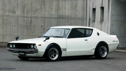 A classic Nissan Skyline parked against a concrete backdrop, showcasing its sleek design and sporty features, serving as a striking HD desktop wallpaper.