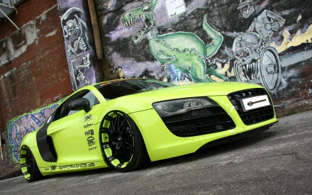 A vibrant lime green Audi R8 sports car parked in front of a graffiti-covered wall, captured in high definition, providing a striking and edgy desktop wallpaper and background.