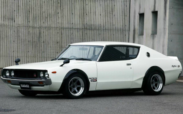 A classic Nissan Skyline parked against a concrete backdrop, showcasing its sleek design and sporty features, serving as a striking HD desktop wallpaper.