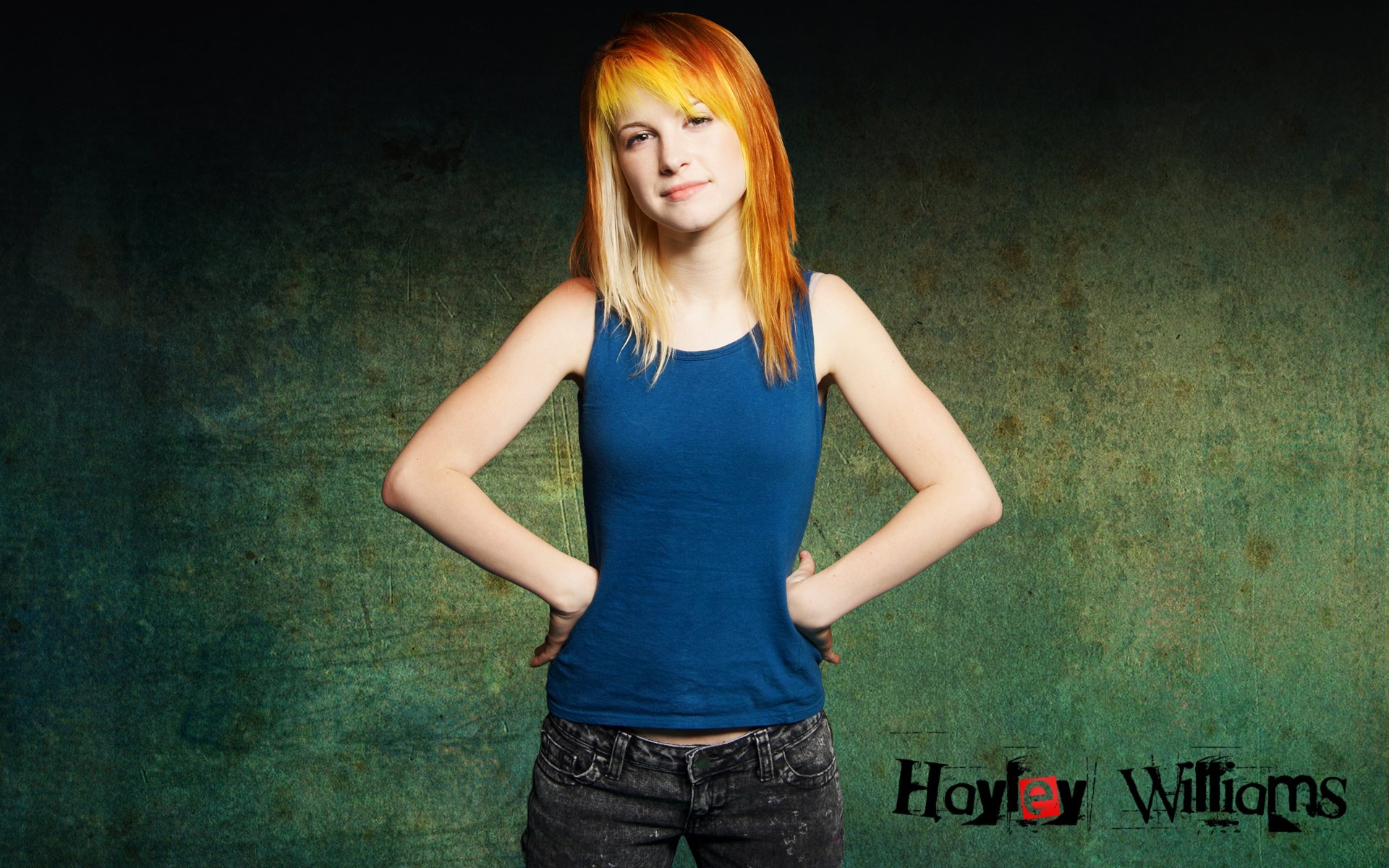 HD desktop wallpaper featuring Hayley Williams standing confidently against a textured green background, showcasing music and vibrant style.