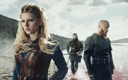 A dramatic HD wallpaper featuring Rollo, Lagertha, and Ragnar Lothbrok from the TV show Vikings, set against a misty landscape by a blood-stained river.