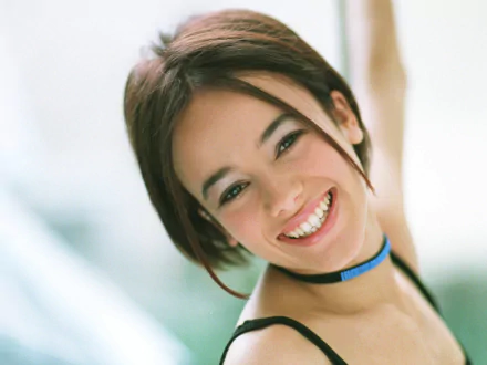HD PC desktop wallpaper featuring a close-up of Alizée smiling, highlighting her music career with a soft, bright background.