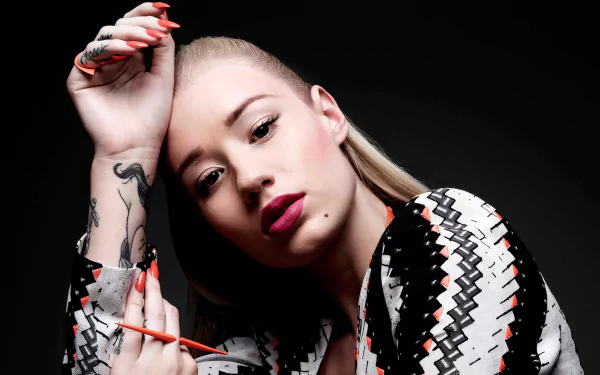Australian rapper and singer Iggy Azalea poses confidently with bold lipstick. Her blonde hair and striking nails add to her edgy style in this HD desktop wallpaper.