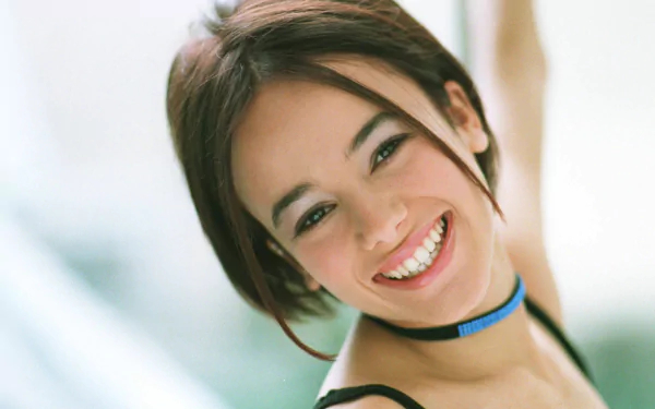 HD PC desktop wallpaper featuring a close-up of Alizée smiling, highlighting her music career with a soft, bright background.