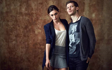 Joseph Morgan and Phoebe Tonkin pose together in a stylish setting, showcasing their characters from the TV show The Originals, captured in an HD desktop wallpaper.
