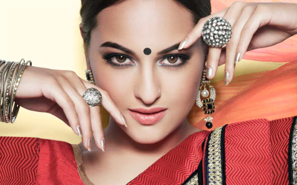 HD desktop wallpaper featuring celebrity Sonakshi Sinha, who is adorned in traditional attire and jewelry, with an elegant pose and confident expression.