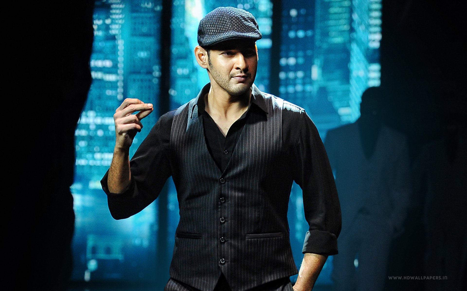 HD PC desktop wallpaper featuring Mahesh Babu in a stylish black outfit from the movie Srimanthudu against a blue cityscape background.