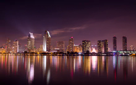 Nighttime cityscape of San Diego with illuminated skyscrapers reflecting on calm water, captured in 4K Ultra HD for a sharp and vibrant desktop background.