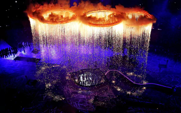 Vibrant fireworks illuminate the night sky over the Olympic Games stadium, creating a dazzling HD PC desktop wallpaper capturing the spirit of sports and celebration.