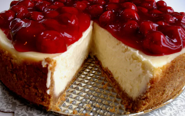 HD desktop wallpaper of a creamy cheesecake topped with glossy cherries, showcasing rich textures and vibrant red hues in a close-up food image.