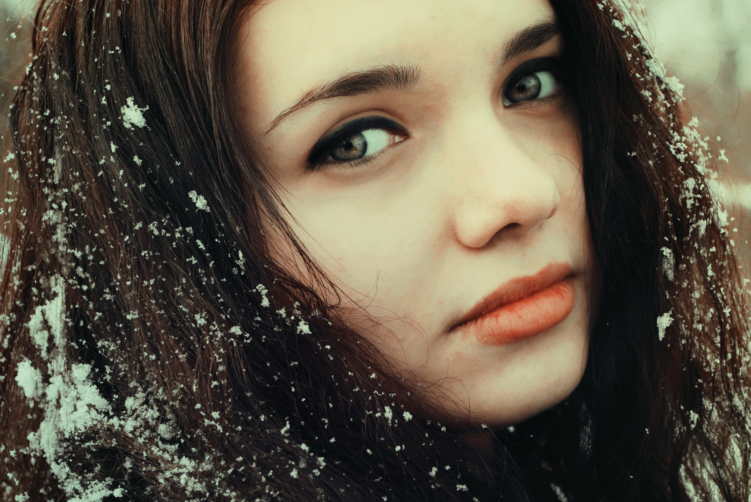 Молодая нежная брюнетка. Темноволосая девушка зимой. Кареглазая девушка зима. Лицо девушки брюнетки. Снег на волосах.