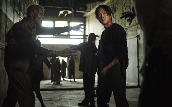 Steven Yeun as Glenn Rhee stands amidst zombies in a tense moment from the TV show The Walking Dead, captured in a dramatic HD wallpaper.