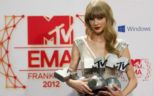 Taylor Swift holding multiple MTV EMA awards at the 2012 event in Frankfurt, captured in HD for a PC desktop wallpaper background.