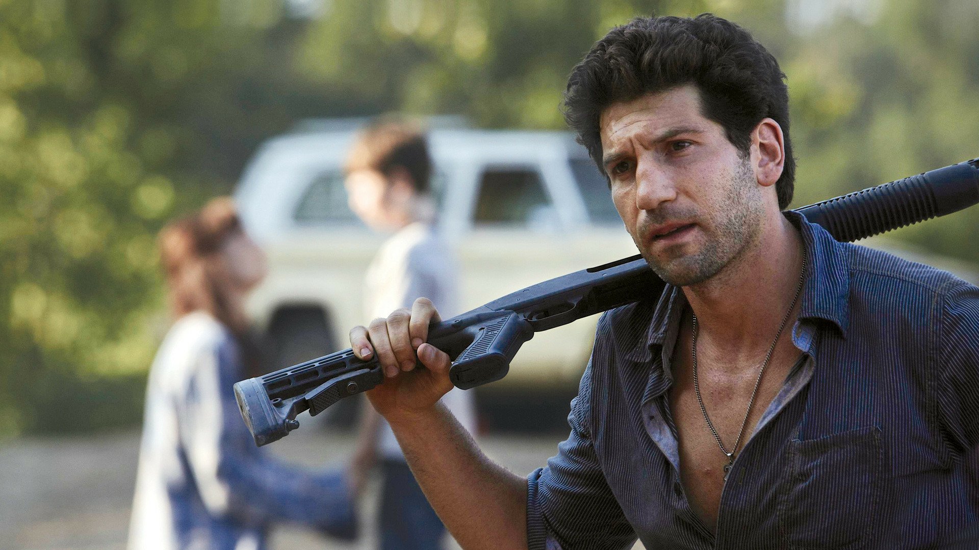 Shane Walsh, portrayed by Jon Bernthal in The Walking Dead, stands ready with a firearm, showcasing the intense atmosphere of the post-apocalyptic series in this HD desktop wallpaper.