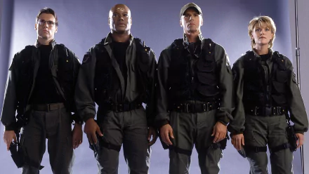 Stargate SG-1 HD PC desktop wallpaper: four uniformed team members in tactical gear standing side by side against a neutral gray backdrop.