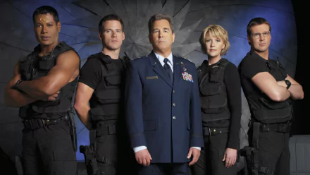 HD desktop wallpaper featuring the main cast of the TV show Stargate SG-1 in tactical gear and military uniform against a dark, sci-fi background.