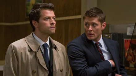Castiel, portrayed by Misha Collins in Supernatural, stands confidently alongside Dean Winchester, played by Jensen Ackles, capturing a tense moment from the beloved TV show.