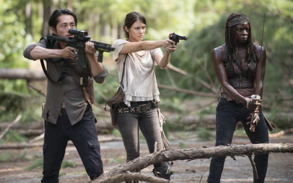 Maggie Greene, Glenn Rhee, and Michonne from The Walking Dead prepare for action in this HD wallpaper, showcasing their characters' resilience and determination.