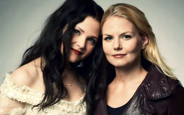 HD wallpaper featuring Snow White and Emma Swan from the TV show Once Upon A Time, showcasing their strong bond and distinct styles against a simple background.