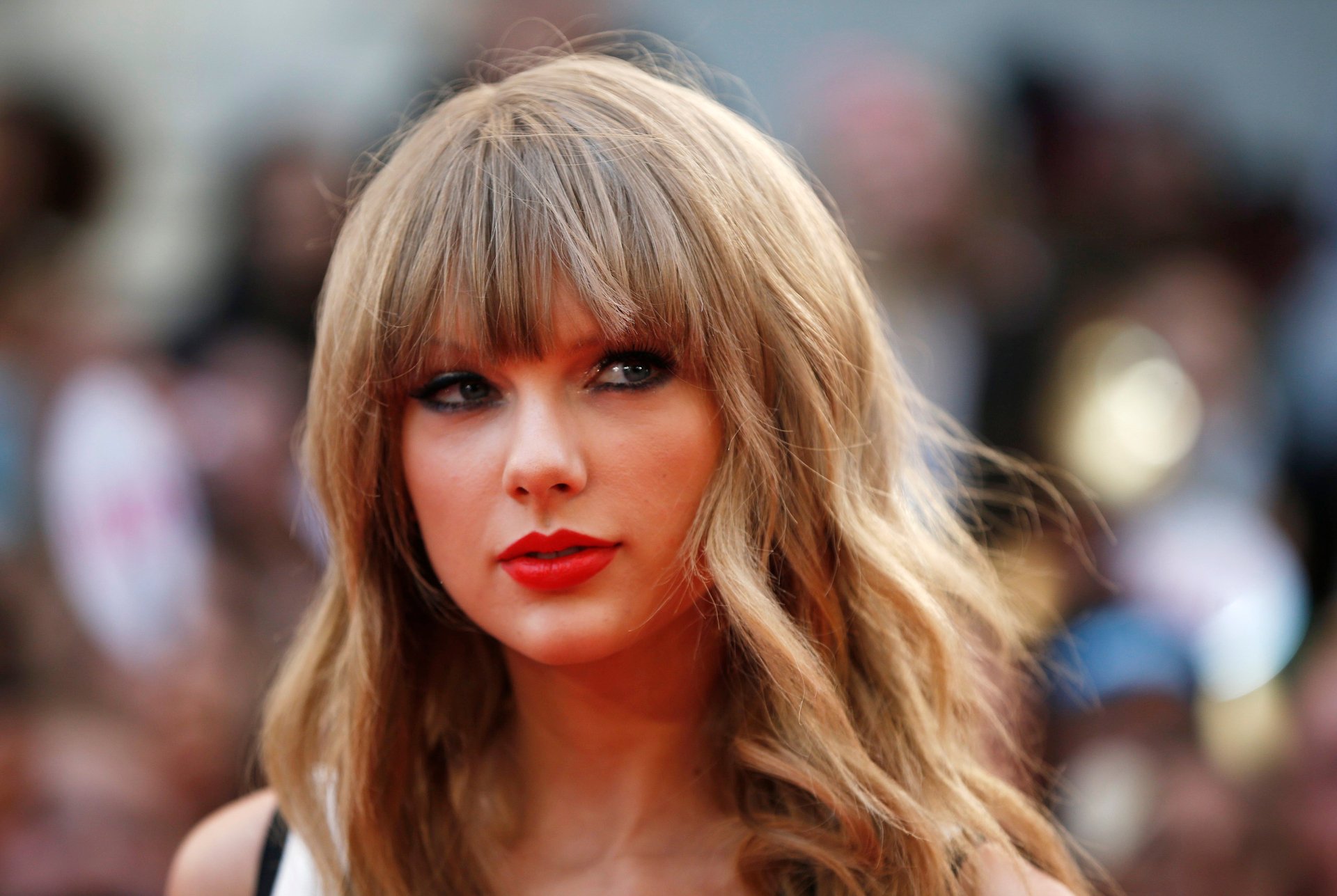 HD PC desktop wallpaper of Taylor Swift, featuring a close-up portrait of the singer with wavy hair and red lipstick, representing music and pop culture.