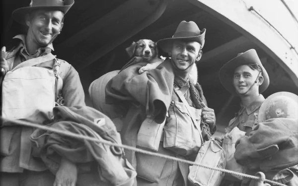 Three soldiers from World War I smile aboard a ship, one holding a dog. The black-and-white image captures their camaraderie and the essence of military life during the era.