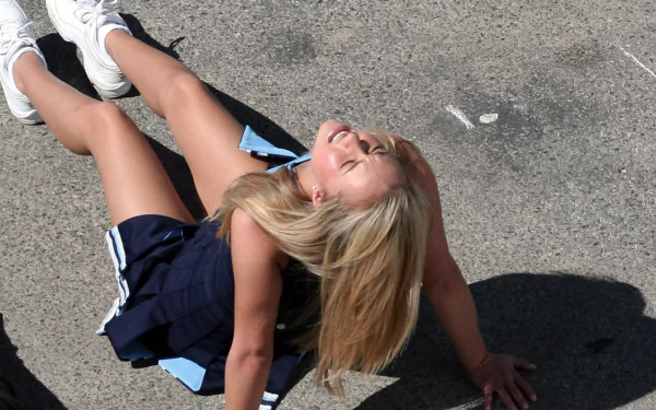 HD desktop wallpaper featuring Hayden Panettiere from the TV show Heroes, captured outdoors in bright sunlight with a joyful expression and casual athletic outfit.