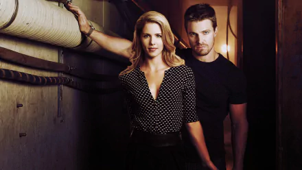 Felicity Smoak and Oliver Queen from the TV show Arrow pose together in a dramatic setting, showcasing their strong connection. A vibrant HD wallpaper for fans of the series.